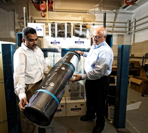 Abheetha Peiris (left) and Issam Harik (right) holding a roll of CatStrong carbon-fiber panels